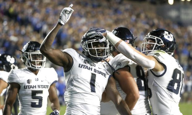 Utah State Aggies wide receiver Ron’quavion Tarver (1) celebrates his touchdown catch with his te...