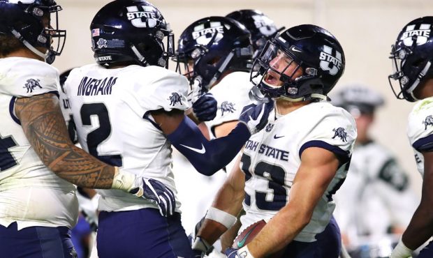 Gaje Ferguson #23 of the Utah State Aggies celebrates a second half interception for a touchdown wh...
