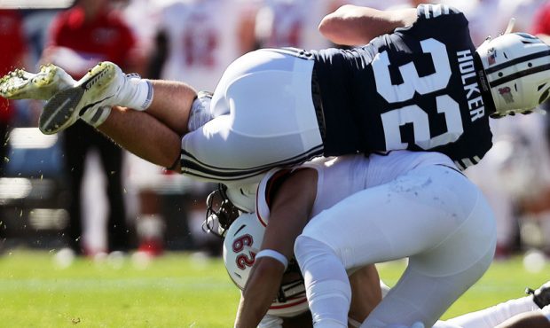 Brigham Young Cougars tight end Dallin Holker is brought down by Northern Illinois Huskies safety A...