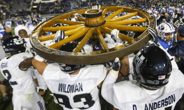 The Utah State Aggies carry the Old Wagon Wheel to midfield after defeating the Cougars and retaini...