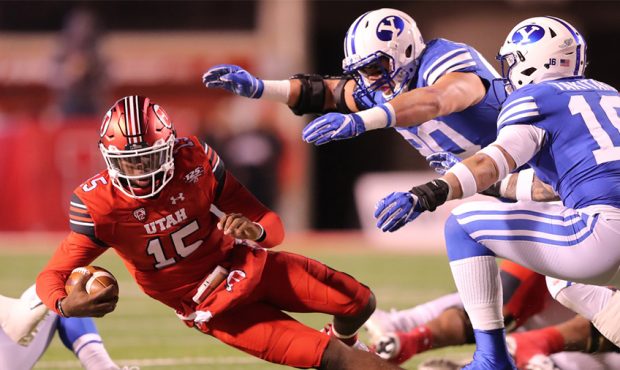 Utah Utes quarterback Jason Shelley (15) falls to the ground as Brigham Young Cougars defensive lin...
