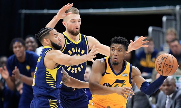 Donovan Mitchell #45 of the Utah Jazz looks to pass the ball while defended by Domantas Sabonis #11...