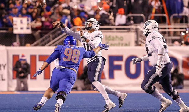 Quarterback Jordan Love #10 of the Utah State Aggies gets a pass away while being pressured by nose...