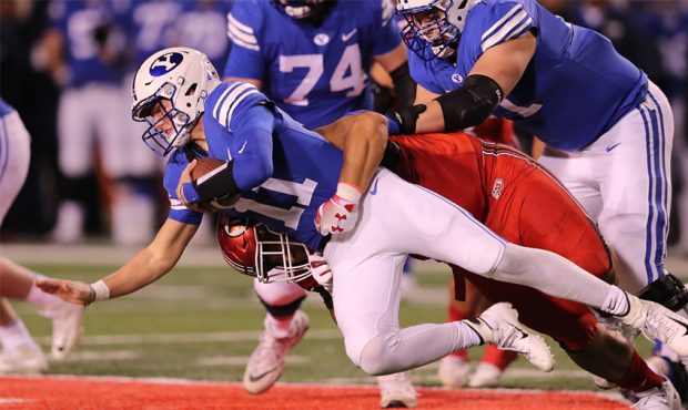 Brigham Young Cougars quarterback Zach Wilson (11) is sacked by Utah Utes defensive tackle Pita Ton...