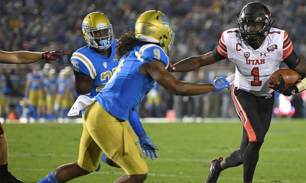 Tyler Huntley #1 of the Utah Utes runs into Elijah Gates #9 of the UCLA Bruins in the second quarte...