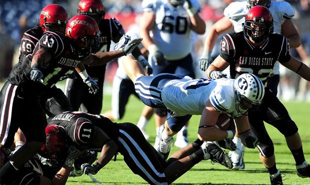 Harvey Unga #45 of BYU Cougars gets tackled by Brandon Kohn #11 of San Diego State Aztecs at Qualco...