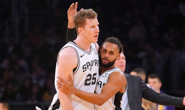Jakob Poeltl #25 and Patty Mills #8 of the San Antonio Spurs react after a foul during the first ha...