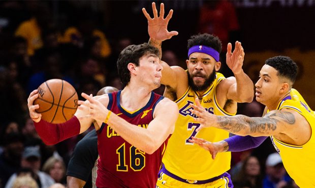 Cedi Osman #16 of the Cleveland Cavaliers looks for a pass while under pressure from JaVale McGee #...