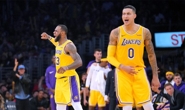 LeBron James #23 and Kyle Kuzma #0 of the Los Angeles Lakers react after a James basket calling for...