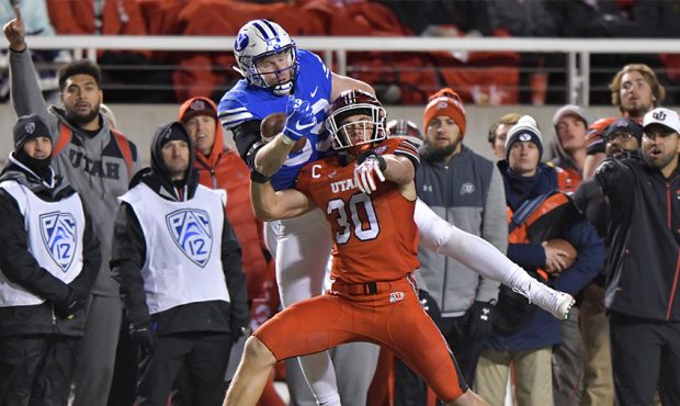 Matt Bushman #89 of the Brigham Young Cougars catches a pass over Cody Barton #30 of the Utah Utes ...