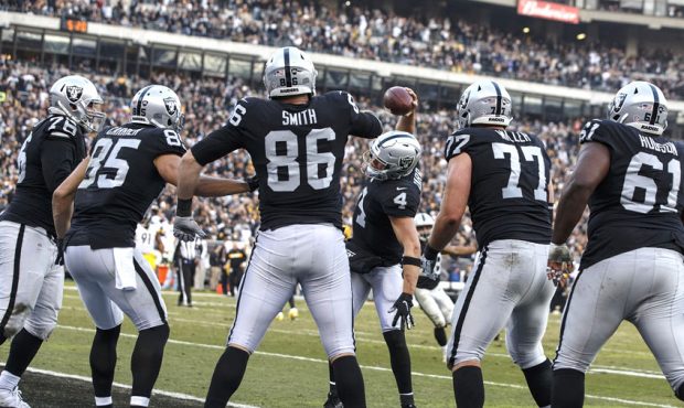 Quarterback Derek Carr #4 of the Oakland Raiders celebrates with tight end Lee Smith #86 after afte...