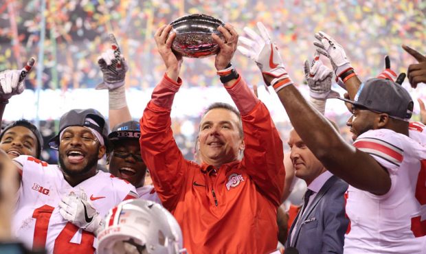 rban Meyer the head coach of the Ohio State Buckeyes holds the winner's trophy after 27-21 win over...
