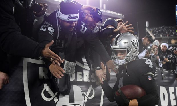 Derek Carr #4 of the Oakland Raiders greets fans in the stands after their 27-14 win over the Denve...