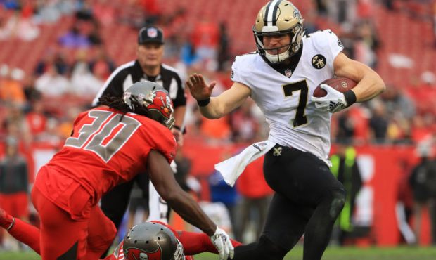 Taysom Hill #7 of the New Orleans Saints breaks a tackle from Adarius Taylor #53 of the Tampa Bay B...
