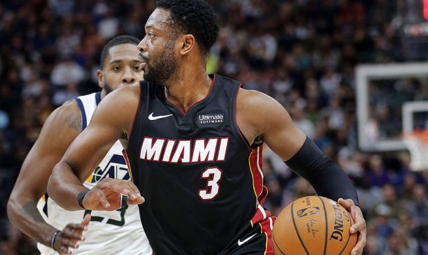 Miami Heat guard Dwyane Wade dribbles the ball with Utah Jazz forward Royce O'Neale defending durin...