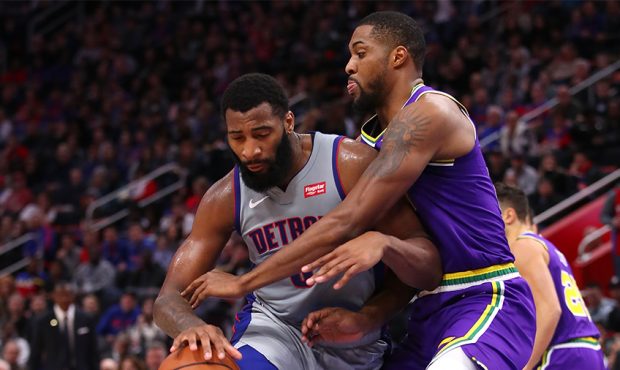 Andre Drummond #0 of the Detroit Pistons tries to get around the defense of Derrick Favors #15 of t...