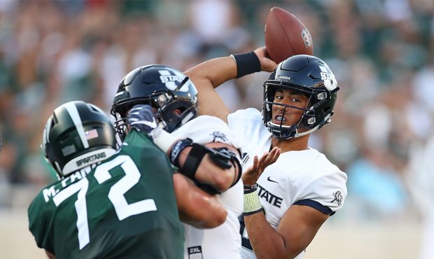 Jordan Love #10 of the Utah State Aggies throws a first half pass behind Mike Panasiuk #72 of the M...