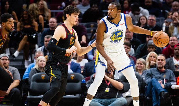 Cedi Osman #16 of the Cleveland Cavaliers guards Kevin Durant #35 of the Golden State Warriors duri...