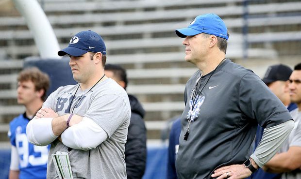 BYU offensive coordinator Jeff Grimes, right, and offensive line coach Ryan Pugh watch players warm...