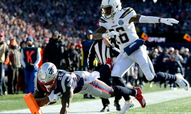 Sony Michel #26 of the New England Patriots scores a touchdown as he is defended by Casey Hayward #...