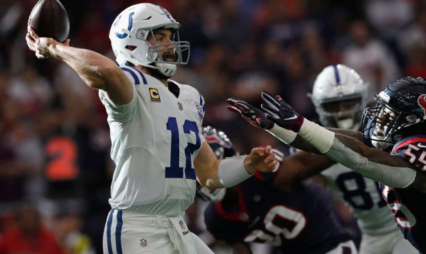 Andrew Luck #12 of the Indianapolis Colts throws a pass under pressure by Benardrick McKinney #55 o...