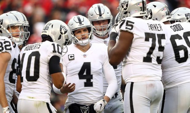Quarterback Derek Carr #4 of the Oakland Raiders huddles with teammates during the game against the...