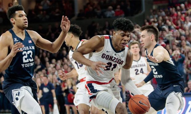 Rui Hachimura #21 of the Gonzaga Bulldogs drives against Yoeli Childs #23 and Zac Seljaas #2 of the...