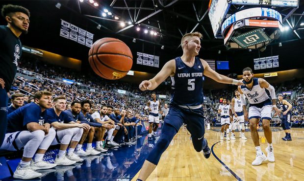 Sam Merrill #5 of the Utah State Aggies points to Cody Martin #11 of the Nevada Wolf Pack as the ba...
