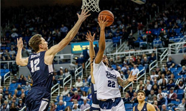 Justin Bean #12 of the Utah State Aggies jumps to block Jazz Johnson #22 of the Nevada Wolf Pack as...