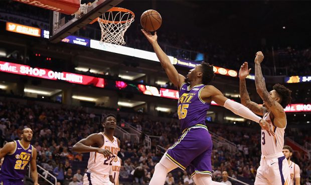Donovan Mitchell #45 of the Utah Jazz lays up a shot past Kelly Oubre Jr. #3 of the Phoenix Suns du...