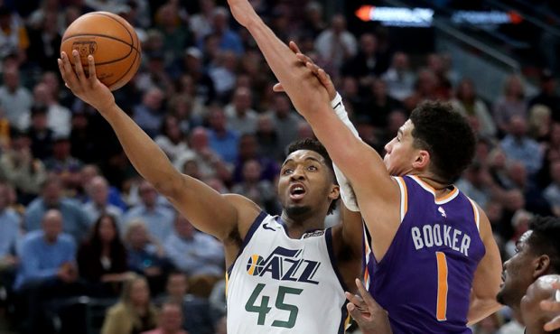 Utah Jazz guard Donovan Mitchell (45) shoots in front of Phoenix Suns guard Devin Booker (1) during...