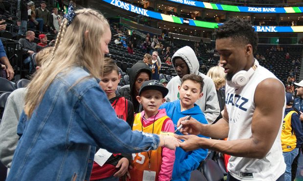 Donovan Mitchell #45 of the Utah Jazz signs autographs for fans during warmups before their game ag...