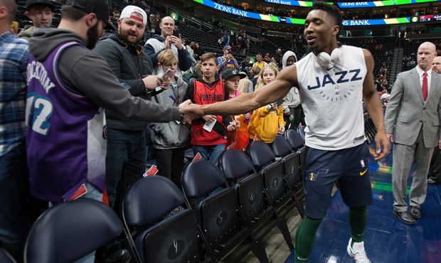 Donovan Mitchell #45 of the Utah Jazz shakes hands with a fan during warmups before their game agai...