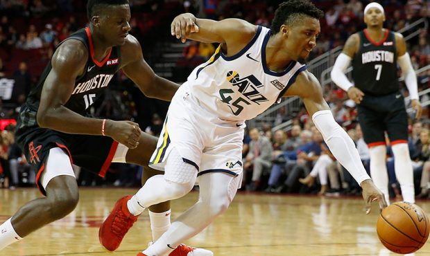 Clint Capela #15 of the Houston Rockets battles Donovan Mitchell #45 of the Utah Jazz for a loose b...