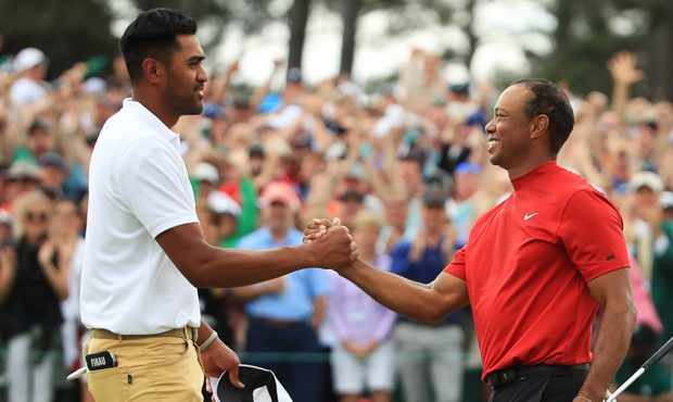 Tony Finau of the United States congratulates Tiger Woods of the United States on his win on the 18...