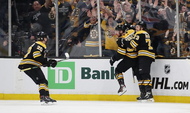 Sean Kuraly #52 of the Boston Bruins is congratulated by his teammates Joakim Nordstrom #20 and Cha...