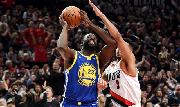 Draymond Green #23 of the Golden State Warriors shoots the ball against CJ McCollum #3 of the Portl...