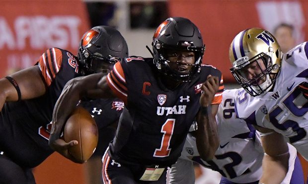 Quarterback Tyler Huntley #1 of the Utah Utes runs with the ball in a game against the Washington H...