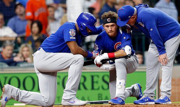Albert Almora Jr. #5 of the Chicago Cubs is comforted by manager Joe Maddon #70 and Jason Heyward #...