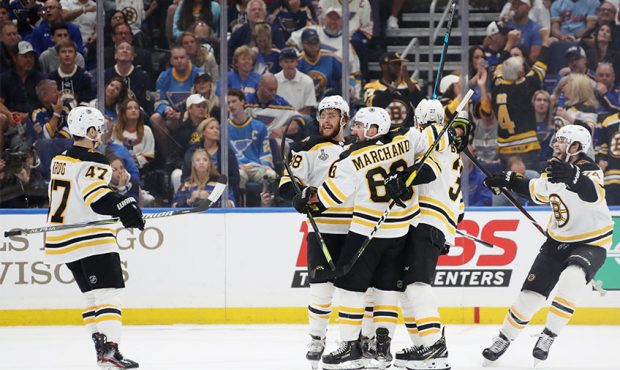 Patrice Bergeron #37 of the Boston Bruins is congratulated by his teammates after scoring a first p...