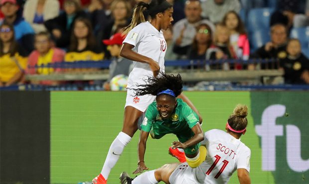 Gabrielle Aboudi Onguene of Cameroon is challenged by Ashley Lawrence of Canada and Desiree Scott o...