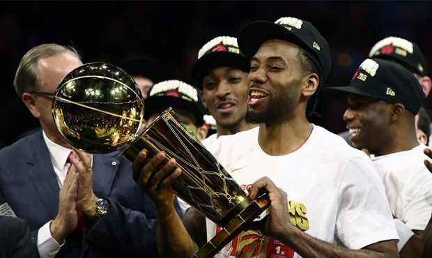 Kawhi Leonard #2 of the Toronto Raptors celebrates with the Larry O'Brien Championship Trophy after...