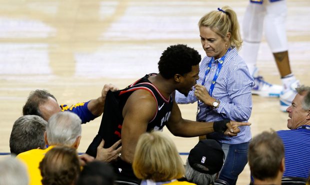 Kyle Lowry #7 of the Toronto Raptors argues with Warriors minority investor Mark Stevens (blue shir...