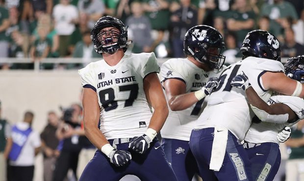 Dax Raymond #87 celebrates a touchdown by an Aggie teammate in Utah State's narrow 38-31 loss to Mi...