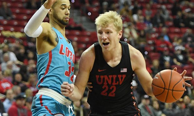 Trey Woodbury #22 of the UNLV Rebels drives to the basket against Anthony Mathis #32 of the New Mex...