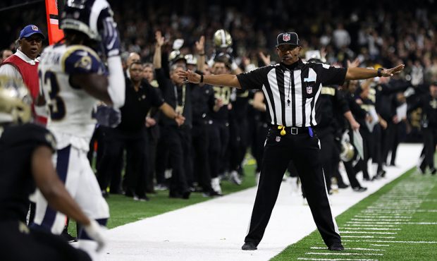A referee watches as Tommylee Lewis #11 of the New Orleans Saints drops a pass broken up by Nickell...