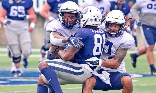 Utah State wide receiver Savon Scarver (81) is brought down after a reception by Aggie defensive ba...