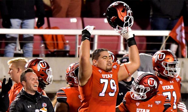 Jordan Agasiva #79 of the Utah Utes, along with others on the bench celebrate a fourth down stop in...