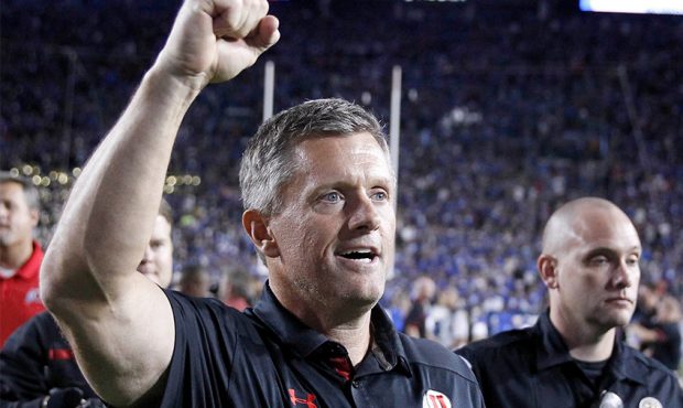 Utah head coach Kyle Whittingham celebrates after a win over the BYU Cougars at an NCAA football ga...