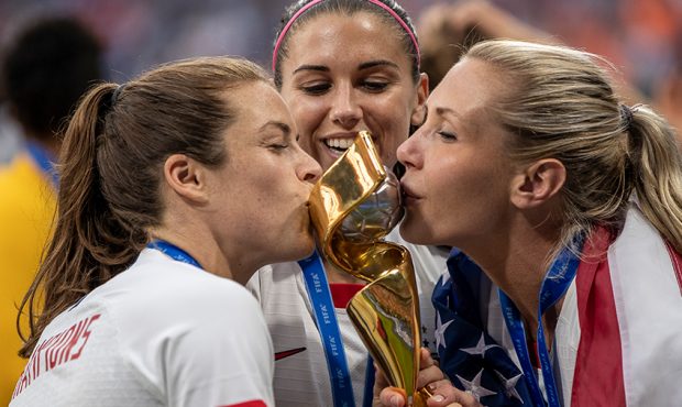 Kelley O'hara, Alex Morgan and Allie Long of the USA celebrate with the FIFA Women's World Cup Trop...